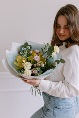 Young beautiful woman with a bouquet of flowers in her hands Gift for March 8 Women's holiday