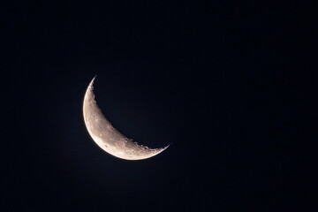 Fototapeta na wymiar Crescent Moon with visible craters, mountains and lunar mare on Clear Sky at Night