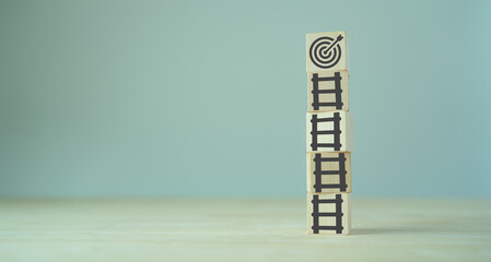 Business goal success concept. rises up Stairs to goal and achieve successful business. Initiation for planning to reach target. Darts target aim icon on wooden cubes with grey background. Copy space - obrazy, fototapety, plakaty