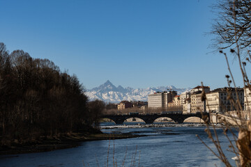 Obraz premium View of the Alps from the city of Torino. Next to the Po' River. Old buildings and Monviso in the background.