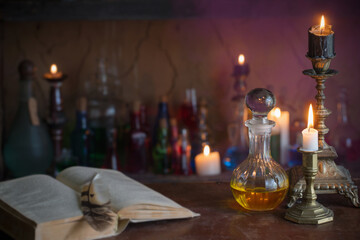 Magic potion, ancient books and candles on dark background