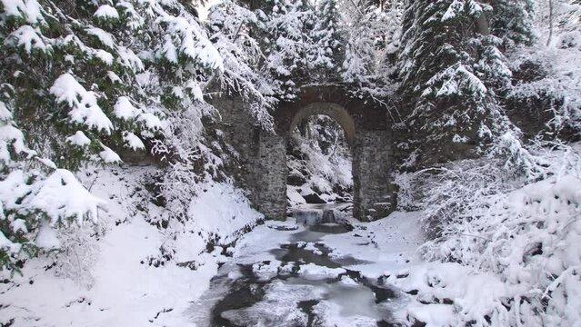 Antique railway bridge viaduct in snowy winter forest in ukrainian Vorokhta