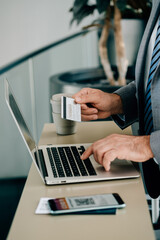Close Up Photo of Man Hands Using Laptop Computer and Credit Card for Making Online Reservation or to Pay Taxes or Fee while Waiting at the Airport