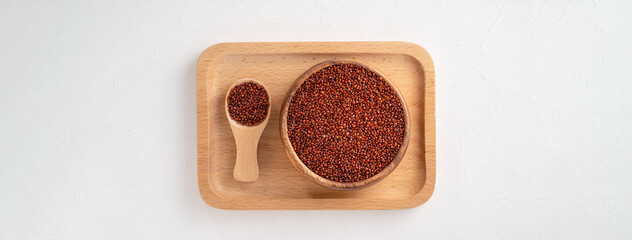 Organic red quinoa in a bowl on white table background.