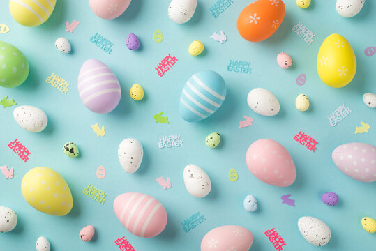 Top view photo of easter decorations inscriptions happy easter multicolored eggs and bunny silhouettes on isolated pastel blue background