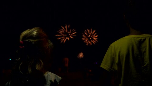 Back view of the children admiring the fireworks at the night