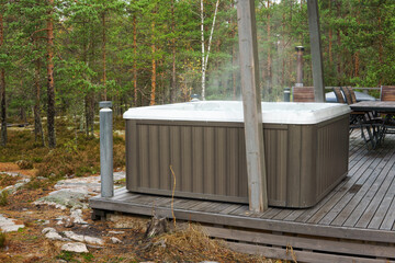 A warm hot tub in a beautiful forest landscape. You can relax outdoors in nature while enjoying the warmth of the hot tub.