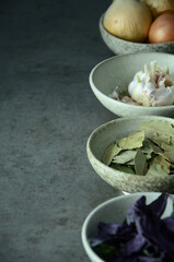 Small ceramic blue bowls with ingredients for cooking on a dark background 