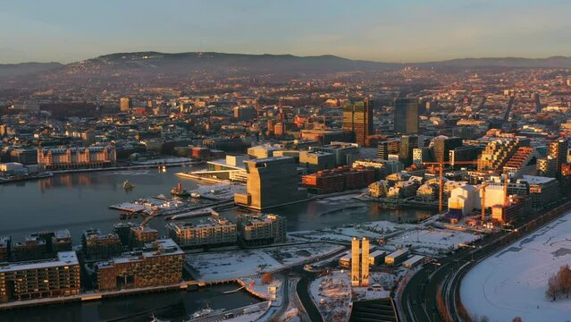 Oslo, Norway. Aerial view of Sentrum area of Oslo, Norway, with modern and historical buildings and car traffic. Grey sky in winter with snow, flying over Oslo