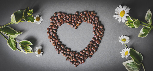 Cafes and restaurants. A mug of invigorating, black coffee and coffee beans in the shape of a heart on a dark gray background. Copy space for text. The concept of hot drinks and love.