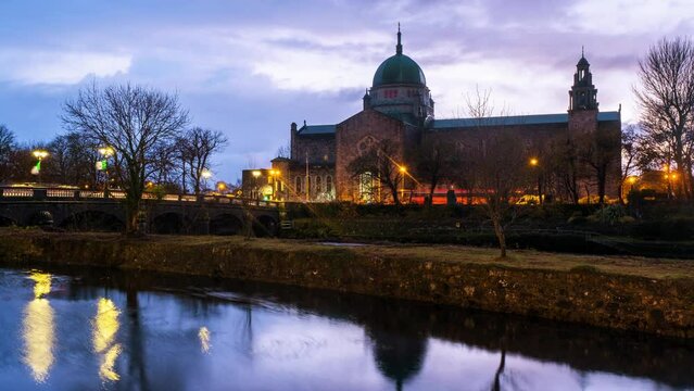 Galway, Ireland. Beautiful landscape of Galway, Ireland. River and famous Galway Cathedral with cloudy colorful sky. Time-lapse during the sunset, zoom in