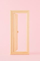 Creative arrangement made of open wooden doors on a pink background. Minimal opportunity and entrance concept.