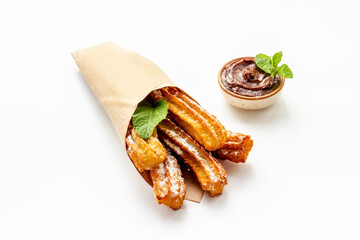 Street food dessert churros in paper bag with sugar