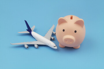 Airplane tickets and saving money concept. Airplane model and piggy bank.