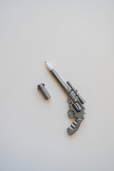 a pen in the form of a pistol lies on a table on a white background. Near the sticker "no war"
