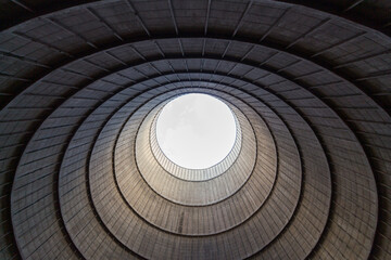 Inside a cooling tower of a nuclear power plant. View upwards, sky with haze