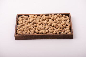 The peanuts in the square plate are on a white background