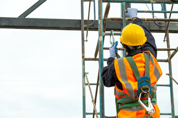 A worker working at height equipment. Fall arrestor device for worker with hooks for safety body...