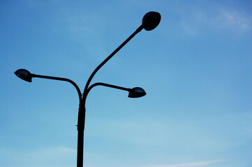 Unlit lamppost with clear blue sky in the background without clouds. Copy space for text. Abstract concept.