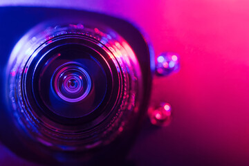 .Camera lens with purple and pink backlight. Optics