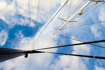 Fototapeta premium Masts of sailing yachts without sails with anchoring ropes. View from below.