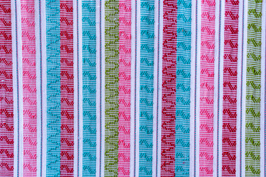 A closeup image of colorful strands of traditional weaving by the Karen people of Myanmar