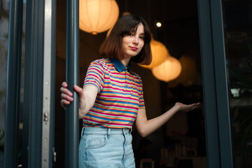 A cute waitress is at the entrance door, inviting you to come to the bar.