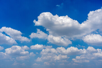 White cumulus clouds on the blue sky background