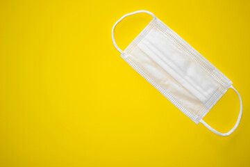 Surgical mask on yellow background