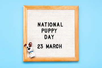 Felt board with text National puppy day in 23 march, cute dog figures on blue background Top view Flat lay Holiday greeting card