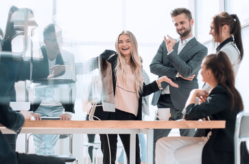 happy group of employees discussing something standing in the office.