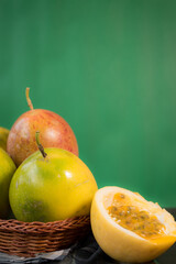 Passion fruit in a basket on a black wooden table with green background 