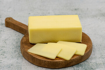 Kashar cheese or kashkaval cheese on stone background. Sliced Cheddar Cheese