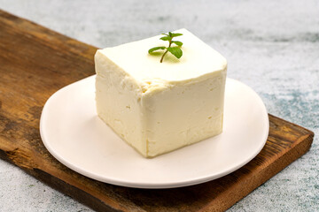 Feta cheese with herbs on stone background. Close-up breakfast cheese