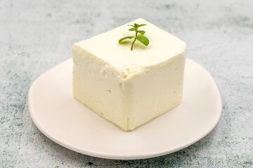 Feta cheese with herbs on stone background. Close-up breakfast cheese