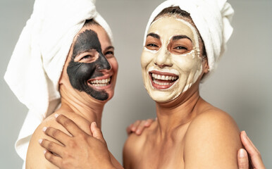 Happy women with facial mask having skin care spa day - People selfcare lifestyle concept