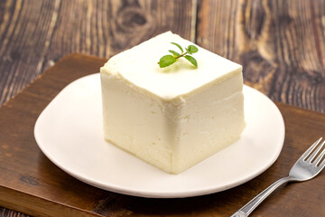 Feta cheese with herbs on wooden background. Close-up breakfast cheese