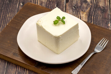 Feta cheese with herbs on wooden background. Close-up breakfast cheese