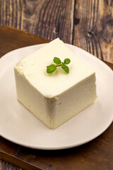 Feta cheese with herbs on wooden background. Close-up breakfast cheese