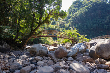 traditional bamboo bridge for crossing mountain river at forest at morning from flat angle