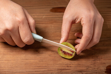 Cut ripe kiwi fruit on a wooden table.