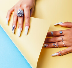 woman hands holding colorful paper copyspace wearing a lot of jewelry and long nails