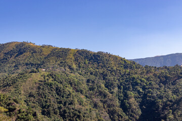 mountain range covered with green forests and misty blue sky at morning from flat angle