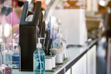 Blue alcohol gel bottle for hand cleaning to prevent the spreading of the Coronavirus (Covid-19) on counter to service for customers at cafe or coffee shop. Healthcare concept. New normal lifestyle.