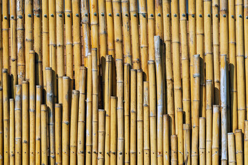 Old brown tone bamboo simple wall or Bamboo fence texture background for interior or exterior design vintage tone. Brown bamboo stick pattern backdrop. Local area urban house protection from thief.