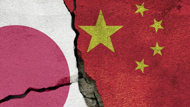 Japan and China national flags painted on cracked concrete wall.
