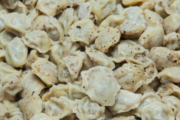 Boiled dumplings sprinkled with spices on top. Background of Dumplings.
