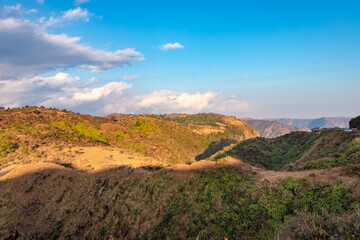 mountain covered with green forests and bright blue sky at afternoon from flat angle