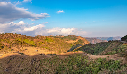 mountain covered with yellow grass and bright blue sky at afternoon from flat angle