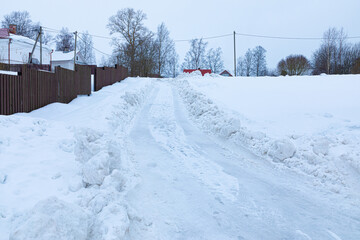 Beautiful, bright, colorful and vivid background of rural snow road in village or little town among low houses